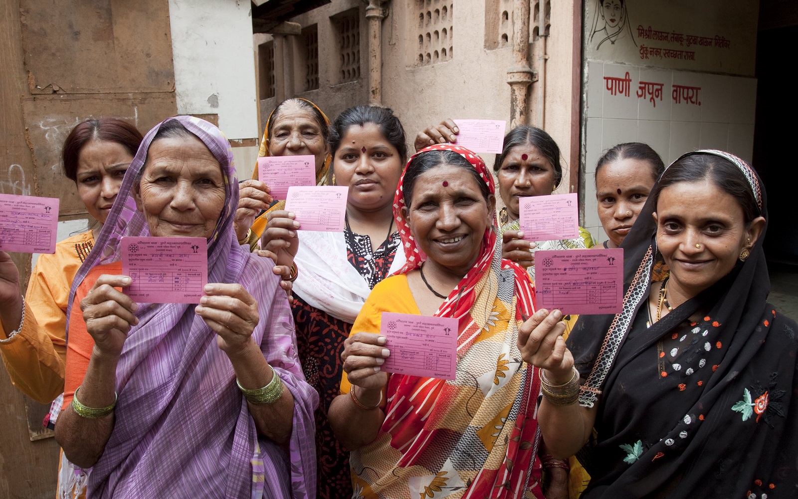 Users with membership cards at a community toilet for women in an urban slum in Pune, India.