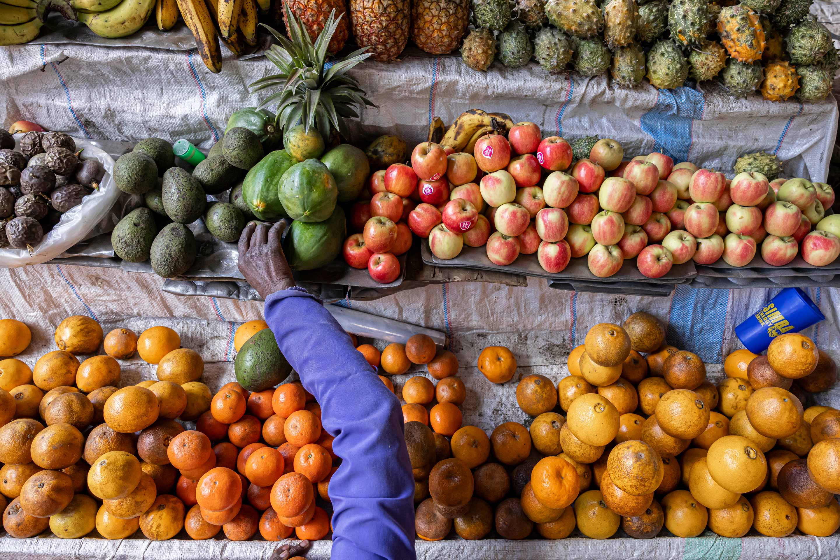 A vendor arranges her fruit stand at Karatina market in Karatina, Kenya.