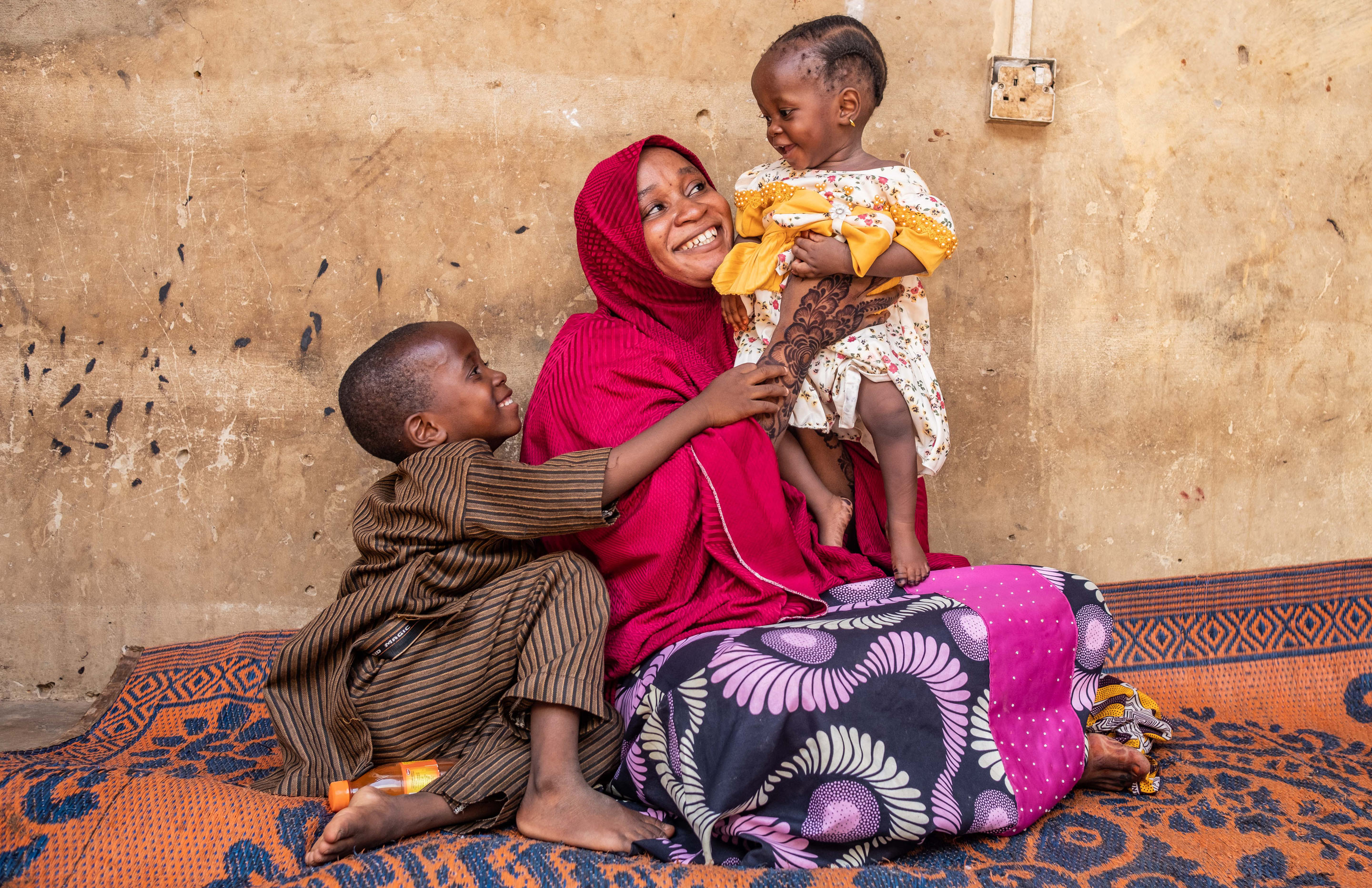 9-month-old Hafsat Abubakar is held by her mother, Safiya Ibrahim, at their home in the Sarkin Adar Gidan Igwai neighbourhood of Sokoto. Hafsat’s older brother, Ismail, sits with them.