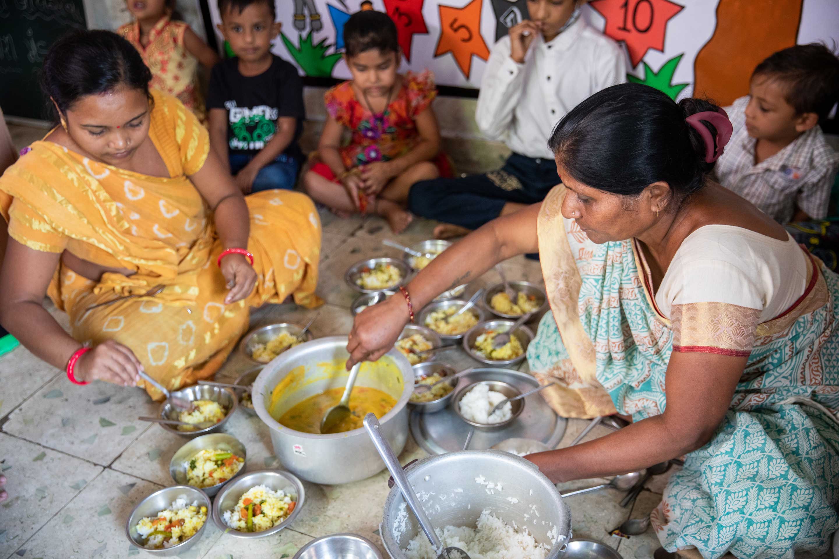 Jashodaben serves lunch to children at the creche she operates and manages in Ahmedabad, Gujarat, India.